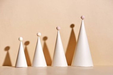 bej renkli arka plan üzerinde kağıttan el yapımı Noel ağaçları