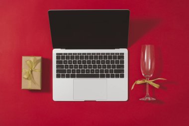 Kırmızı zemin üzerine laptop ve Noel süslemeleri ile çalışma alanı