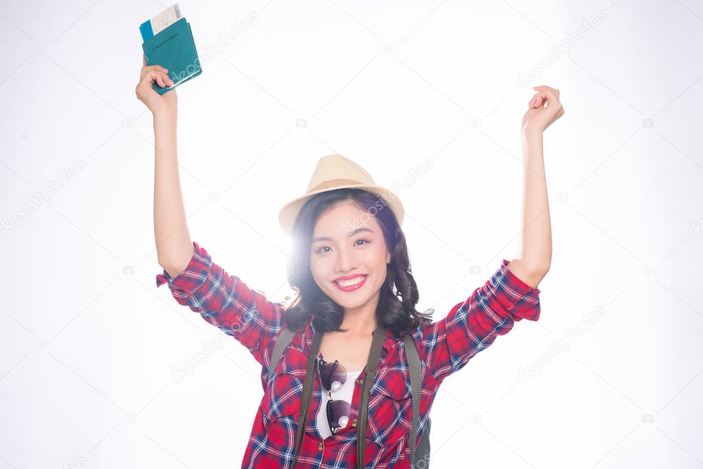 Young beautiful asian woman in hat holding passport and air ticket on white background