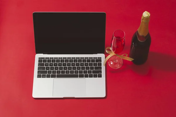 Workspace with laptop and christmas decorations on red background