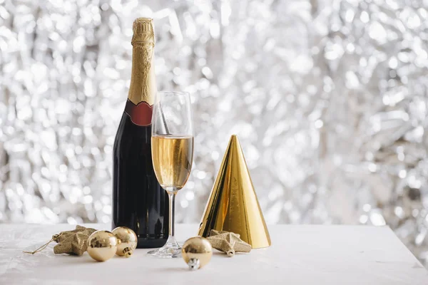 Bicchiere Champagne Bottiglia Con Cappello Carta Ornamenti Natalizi Sfondo Argento — Foto Stock