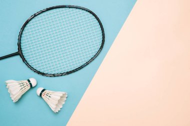 Shuttlecocks ve pembe ve mavi yüzeyinde badminton oynamak için raket