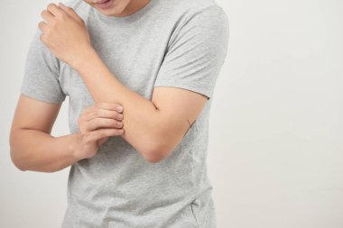 Adam beyaz arka plan üzerinde el ile kaşıntı tırmalamak