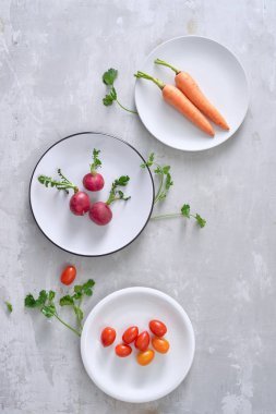 maddeler üzerinde izole bir tabak içinde çeşitli gri - havuç, turp ve erik domates