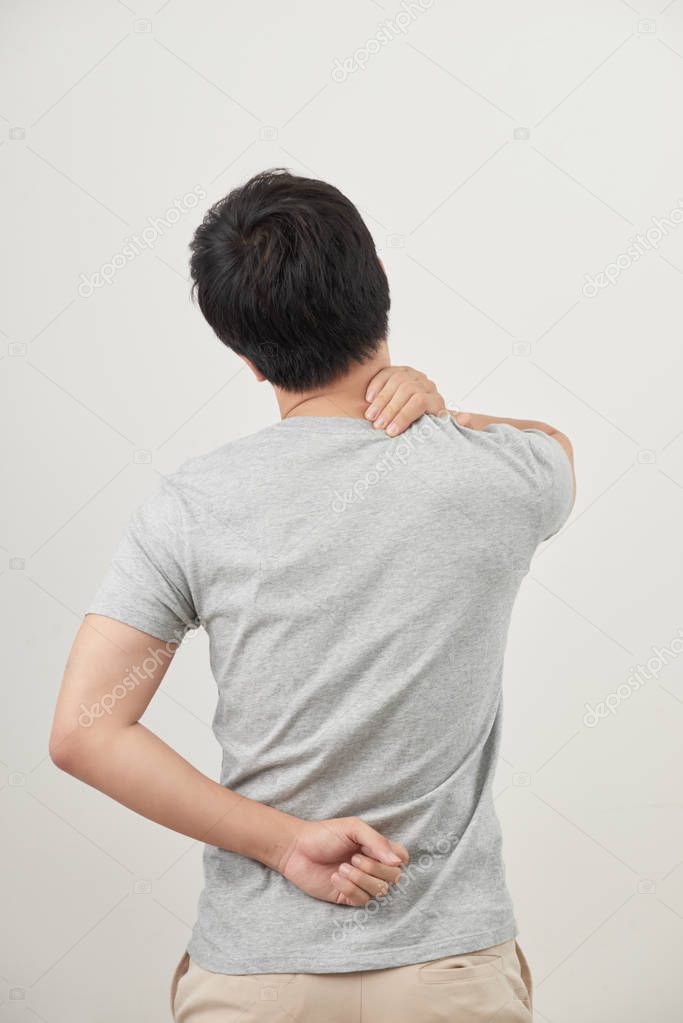 Man rubbing painful back on white background