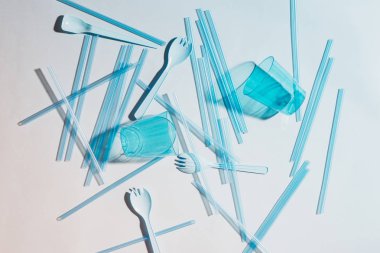 çatal bıçak takımı ve beyaz zemin üzerine gözlük ile mavi plastik çubuk