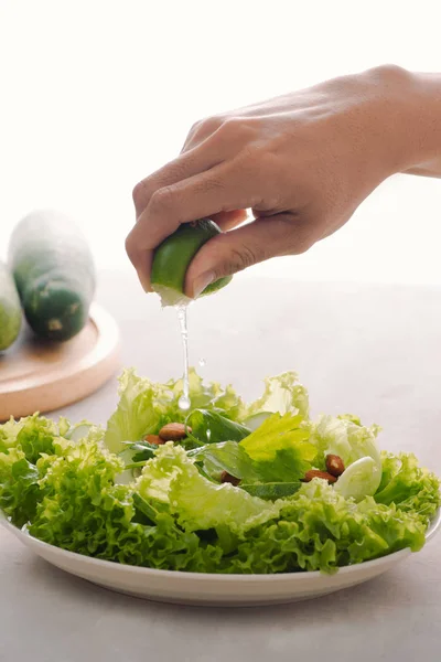 Mão Feminina Espremendo Limão Fresco Salada Verde Placa — Fotografia de Stock