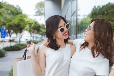Satılık, tüketim ve insanlar kavramı - genç kadınlarla mutlu şehir sokak üzerinde alışveriş torbaları