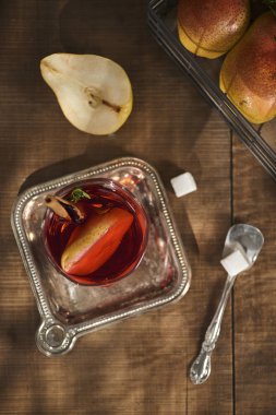 Ev yapımı sıcak sıcak armut şarabı bir ahşap zemin üzerine tarçın çubuğu ile 