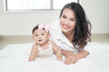 Genç kadın ve katta oynarken küçük bebek kız