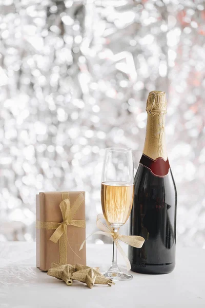 Champagner Glas Und Flasche Mit Geschenkbox Und Weihnachtsschmuck Auf Silbernem — Stockfoto