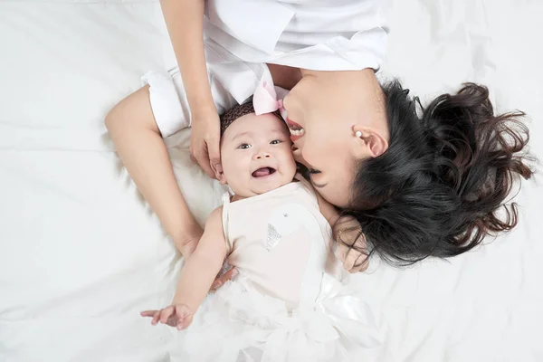 Mother Kissing Cute Baby Girl Lying Bed — Stock Photo, Image