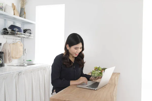 Mujer Joven Con Ensalada Trabajando Ordenador Portátil Cocina — Foto de Stock