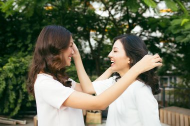 güzellikleri tarzı. iki güzel genç iyi giyimli kadınlar ayakta açık havada kucaklayan yaparken kameraya gülümseyen