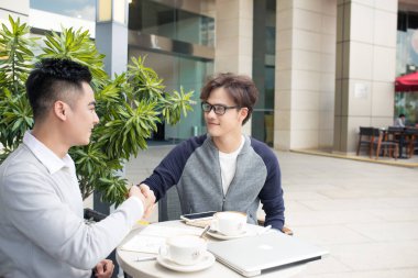 Açık havada kafede tokalaşırken işadamları