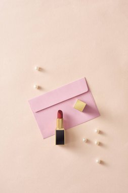 pastel arka plan üzerinde İncili pembe zarf üzerinde ruj