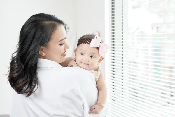 Feliz Madre Sosteniendo Bebé Niña Ventana —  Fotos de Stock