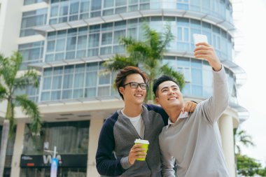 iki yakışıklı genç Asyalı erkek selfie ile smartphone ofis binası önünde alarak