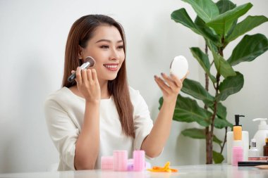 makyaj fırça ayna önünde ile uygulayarak genç güzel kadın