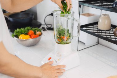 sağlıklı beslenme, yemek, vejetaryen yemek, diyet ve kavram insan - detoks sallamak yapım blender ve yeşil sebze ya da iki yüzlü ile tatil ışıklar arka plan üzerinde genç adam kapat