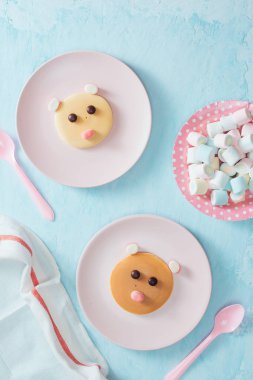 Mavi zemin üzerine plakalar üzerinde çocuklar için oyuncak ayı şeklinde komik krep