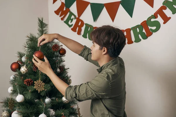 Homem Bonito Decorando Árvore Natal Com Bugigangas Casa — Fotografia de Stock