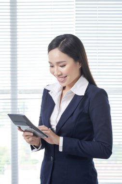 Parlak Office hesap makinesini kullanarak Asya iş kadını gülümseyen