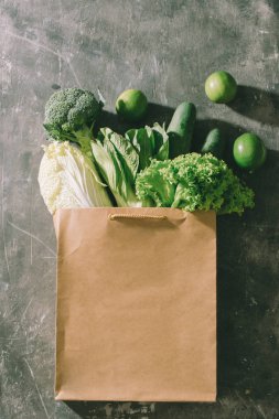 kahverengi alışveriş çantası gri yüzeyi yeşil sebze