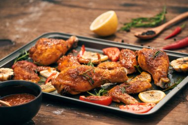 Kavrulmuş tavuk kanatları ve tepsi pişirme üzerinde sopaları