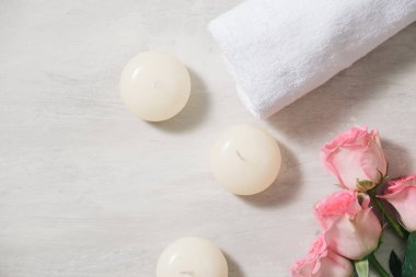 Mumlar ve havlu Spa beyaz yüzeyindeki çiçeklerle