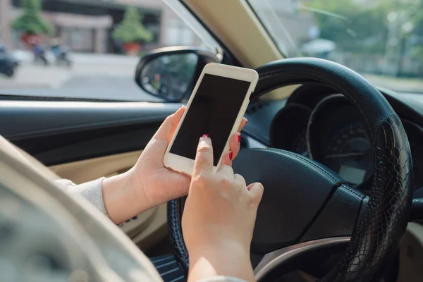 Nuori Naiskuljettaja Käyttää Kosketusnäytön Älypuhelinta Kädessä Pidettävää Ohjauspyörää Autossa — kuvapankkivalokuva