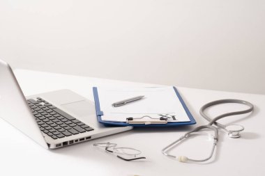Stetoskop, hap, beyaz arka plan üstünde laptop. Tıp kavramı 