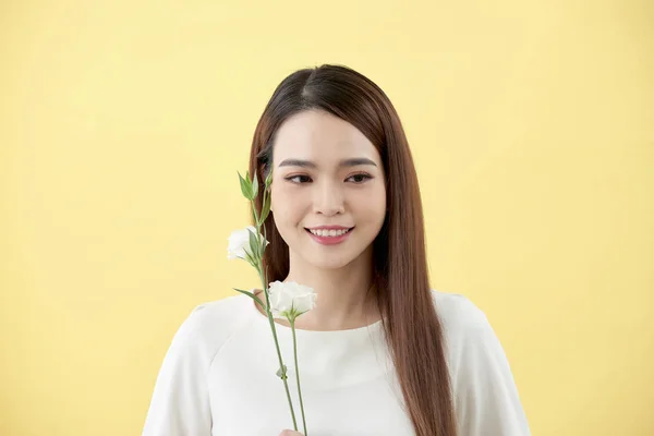 20岁的女士的美丽肖像举行白色的花在黄色背景 — 图库照片
