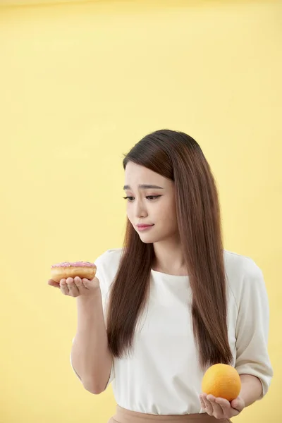 Retrato Uma Jovem Asiática Sorrindo Escolhendo Entre Donut Laranja Isolado — Fotografia de Stock