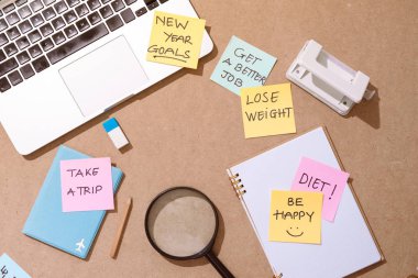 Büyüteç cam ve ahşap masa üzerinde yeni yıl hedef kelime yazılı yapışkan not