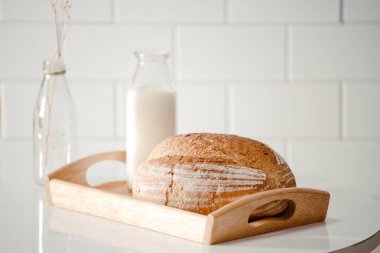 Cam şişe süt ekmek gıda ve sağlıklı kavramı için beyaz arka plan üzerinde izole ahşap tepsi ile. kopya alanı ile metin için
