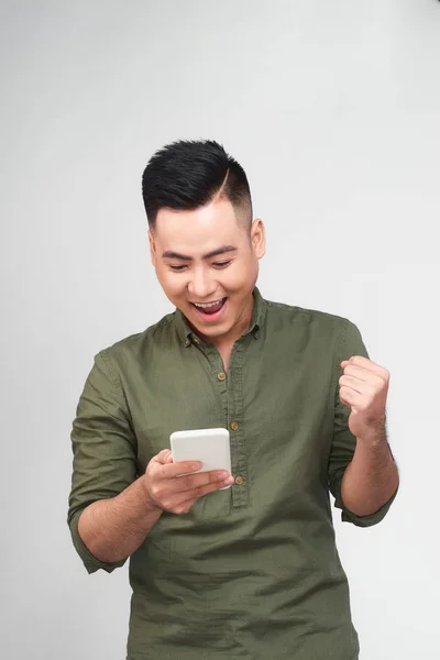Šťastný Muž Držící Smartphone Slaví Svůj Úspěch Nad Šedým Pozadím — Stock fotografie