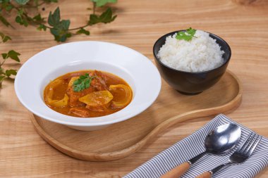 Ahşap arka plan üzerinde bir kapta tavuk köri ile lezzetli akşam yemeği