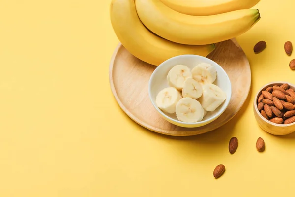 Bananas and banana slices on a plate of wood.