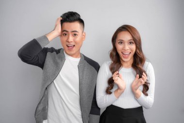 Güzel genç çift ayakta ve bir stüdyoda şaşırmış duygu