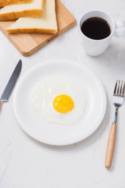 Kızarmış yumurta tost ve kahve masada