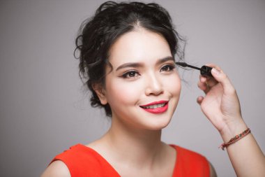 Asyalı bir kadın onun kirpik rimel uygulamak