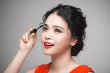 Asyalı bir kadın onun kirpik rimel uygulamak