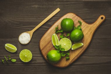 Taze dilimlenmiş limon ve tuz ahşap masa üzerinde.