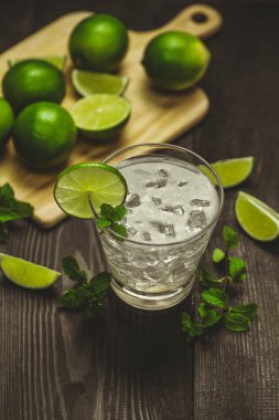 Bardak su kireç, buz ve nane ile. Ahşap arka plan üzerinde izole.