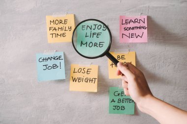 Group of New year Resolution Notes on pink, yellow, orange and green on wall written with message of diet, join gym, find love and be happy