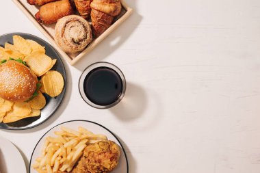 Fast food ve sağlıksız beslenme kavramı - kadar yakın lokanta aperatifler ve cola içecek beyaz masada 