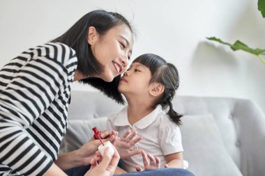 Anne ve kızı oje sürerken eğleniyorlar, aile zamanı konsepti.