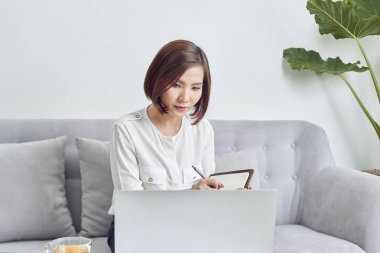 Kafede dizüstü kullanarak Asyalı kadın ve bazı verileri Not defteri üzerinde Not