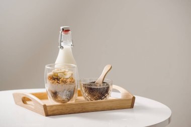 Sağlıklı yemeye hazır besleyici bir kahvaltı - granola badem, chia tohum, muz ve Kivi Meyve ve çilek ile ve süt ile bir kavanoz